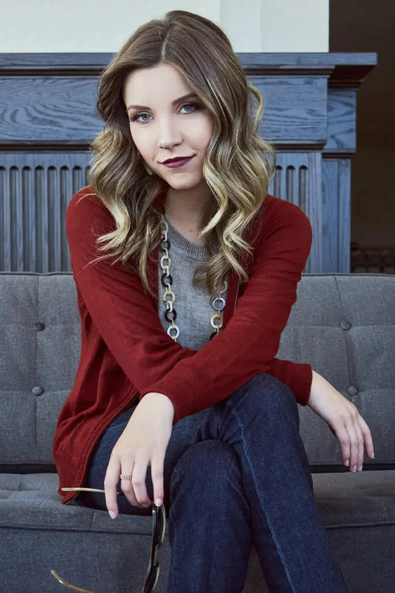 a seated view Gaby Woman Cardigan sweater Qiviuk in Red made by Qiviuk Boutique