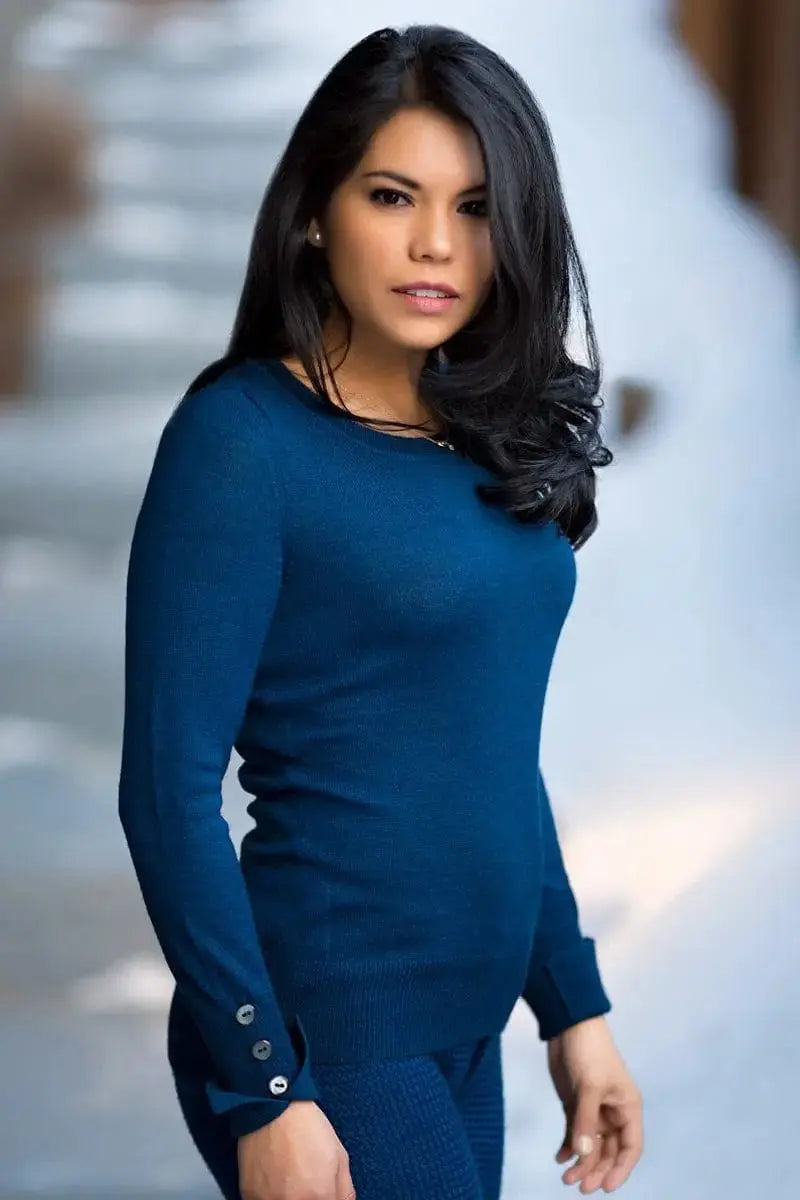 A side view of a blue Angela Woman Petite Pullover, Qiviuk, Merino & Silk by Qiviuk Boutique