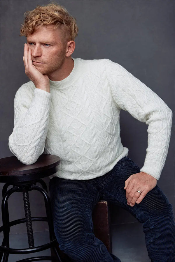 A man in a white Fisherman Unisex Pullover Sweater  Merino by Qiviuk Boutique